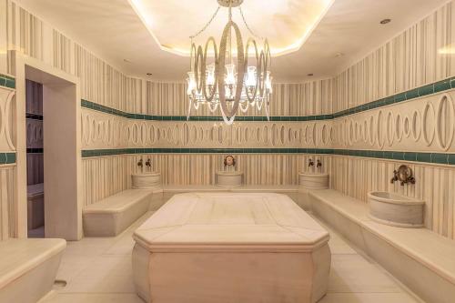 a large room with a chandelier and two sinks at Wyndham Grand Istanbul Kalamış Marina Hotel in Istanbul