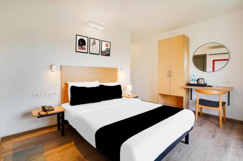 a hotel room with a large bed and a mirror at Super Townhouse BTM Layout Near Madiwala Lake Formerly Q Rooms in Bangalore