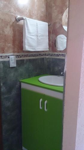 a green bathroom with a sink and a mirror at Terrazas de Villa Gloria in Villa Giardino