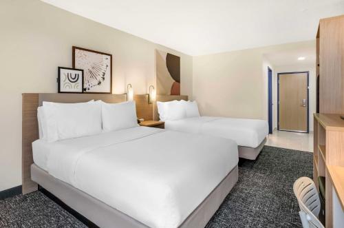 a hotel room with two beds and a tv at Spark By Hilton Roanoke Airport in Roanoke