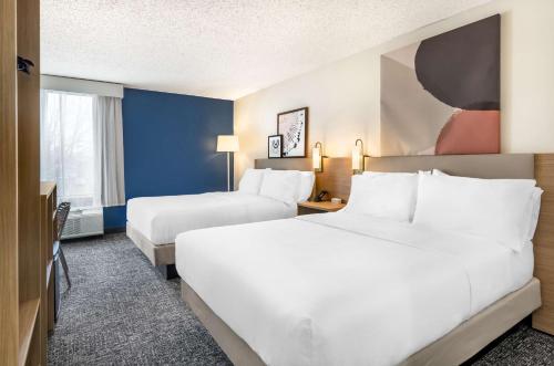 a hotel room with two beds and a tv at Spark By Hilton Roanoke Airport in Roanoke