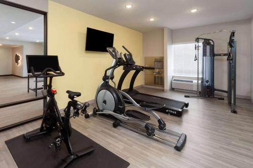 a gym with two exercise bikes and a mirror at ECHO Suites Extended Stay by Wyndham Madison in Madison