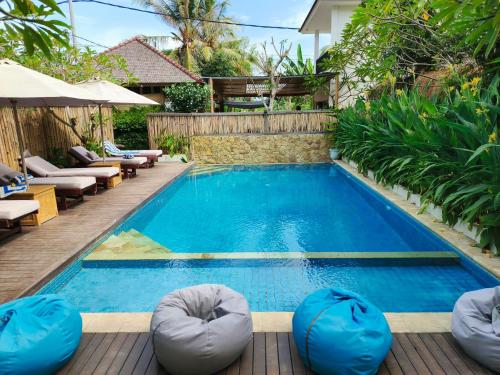 a swimming pool with bean bags in front of a house at Lavella Villas Kuta Lombok in Kuta Lombok