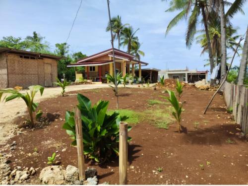 a house with a yard with trees and a fence at turtels place- Chay's Bungalow in Esperanza