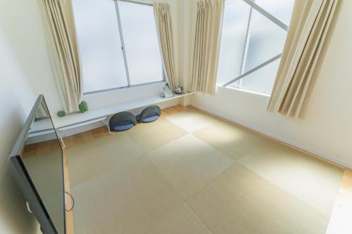 a room with two windows and a pair of shoes on the floor at Flower Base Lily House - Vacation STAY 55522v in Fukuoka