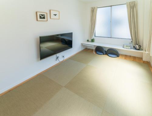 a living room with a flat screen tv and a pair of shoes at Flower Base Lily House - Vacation STAY 55522v in Fukuoka