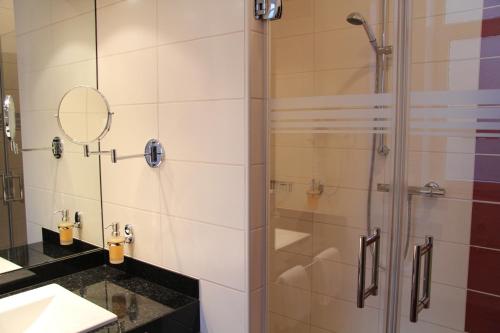 a bathroom with a shower with a glass door at Adena Hotel in Bremerhaven