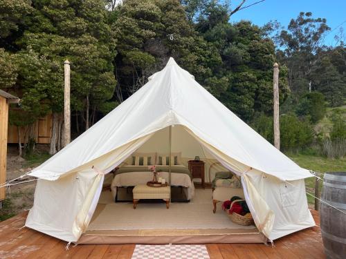 a white tent with a bed and chairs in it at Fairy Wren Off Grid Luxury Glamping Retreat in Wine Country in Lilydale
