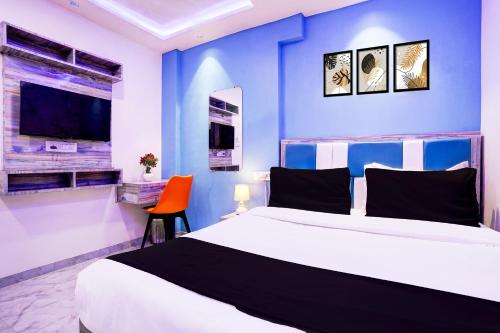 a bedroom with a large bed and a blue wall at Collection O Goregaon Near Film City Formerly Cupid in Mumbai