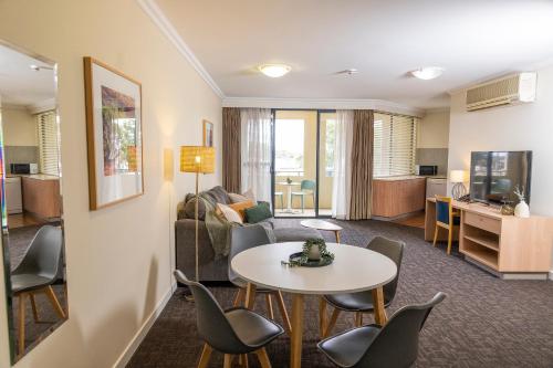 un salon avec un canapé, une table et des chaises dans l'établissement Rydges Kalgoorlie, à Kalgoorlie