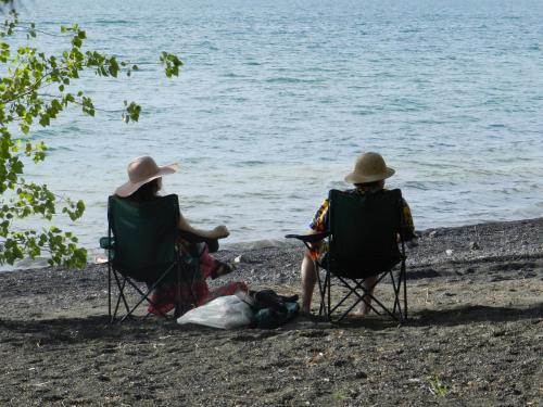 two people sitting on a beach next to a body of water at Magma Lodge, Pucon in Pucón