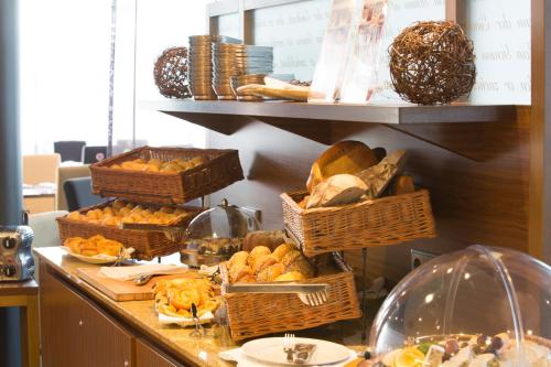 a buffet line with baskets of bread and other foods at Dorint Hotel am Dom Erfurt in Erfurt