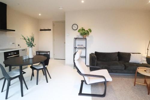 a living room with a couch and a table and chairs at Zilt aan Zee in Egmond aan Zee