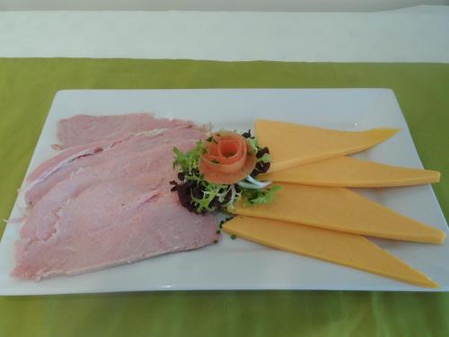a piece of meat on a white plate with cheese at Midtown Farm Bed & Breakfast in Easton