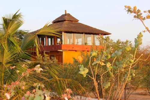 a building with a roof on top of some trees at Le Lodge Dalaal Diam in Somone