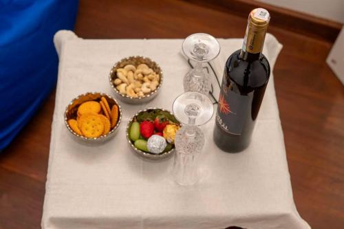 a table with a bottle of wine and bowls of food at Liora Homestay in Gelioya