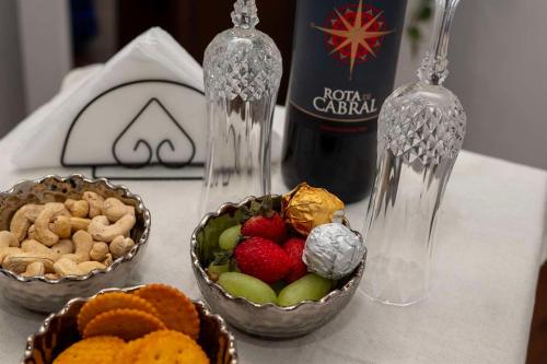 a table with two bowls of fruit and a bottle of wine at Liora Homestay in Gelioya