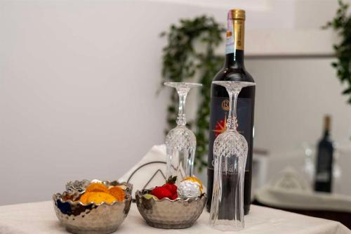 a table with two wine glasses and two bowls of fruit at Liora Homestay in Gelioya