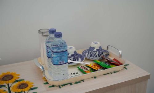 a table with a bottle of water and other items on it at Liora Homestay in Gelioya