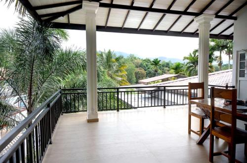 a balcony of a house with a view of the ocean at Liora Homestay in Gelioya