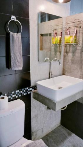 a bathroom with a sink and a toilet and a mirror at Villa Rajapruek Private Villa 3 houses combine near Airport in Chiang Mai