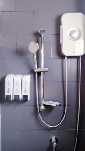 a shower in a bathroom with a hose on a wall at Villa Rajapruek Private Villa 3 houses combine near Airport in Chiang Mai