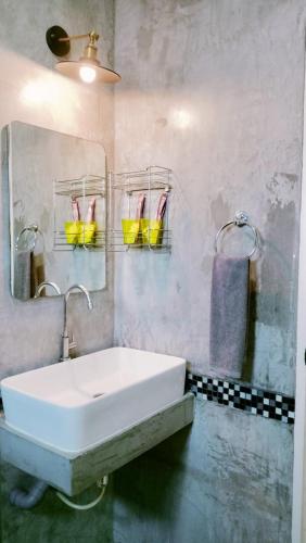 a bathroom with a white sink and a mirror at Villa Rajapruek Private Villa 3 houses combine near Airport in Chiang Mai