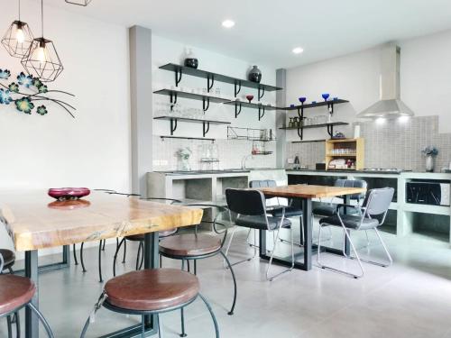 a kitchen with wooden tables and chairs and shelves at Villa Rajapruek Private Villa 3 houses combine near Airport in Chiang Mai
