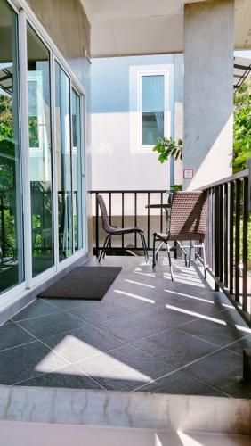 a patio with two chairs on a balcony at Villa Rajapruek Private Villa 3 houses combine near Airport in Chiang Mai