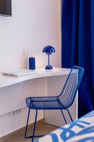 a blue chair sitting next to a desk with a lamp at Rooms Indigo Bundek in Zagreb