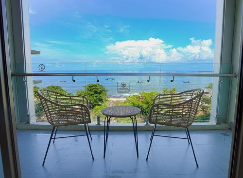 three chairs and a table in front of a window at Platinum Hotel Jimbaran Beach Bali in Jimbaran