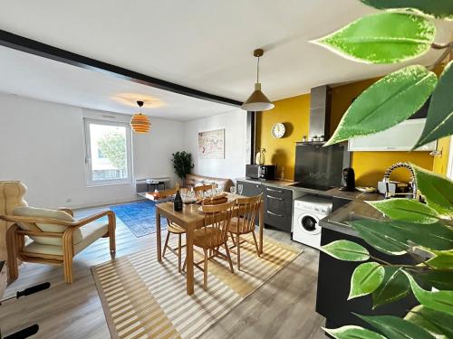 une cuisine et un salon avec une table et des chaises dans l'établissement Laon T3 moderne terrasse et babyfoot proche centre, à Reims
