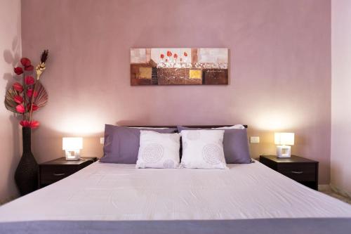 una camera da letto con un grande letto con due comodini di Seaside Holidays ad Alghero