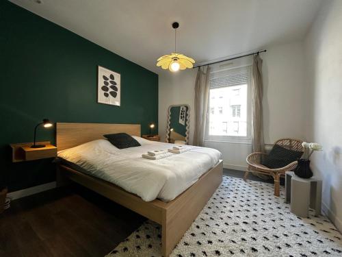 une chambre avec un grand lit et un mur végétal dans l'établissement Laon T3 moderne terrasse et babyfoot proche centre, à Reims