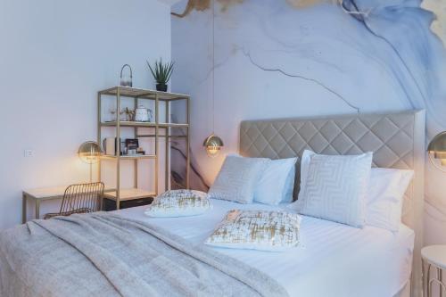 a bedroom with a large white bed with two pillows at Rooms Indigo Bundek in Zagreb