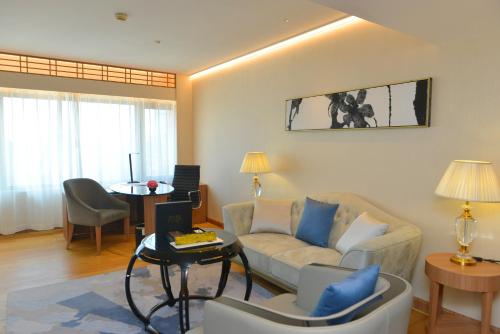 a living room with a couch and a table at The Garden Hotel Guangzhou - Discover 26 cultural treasures with hotel Golden Tour Guide in Guangzhou