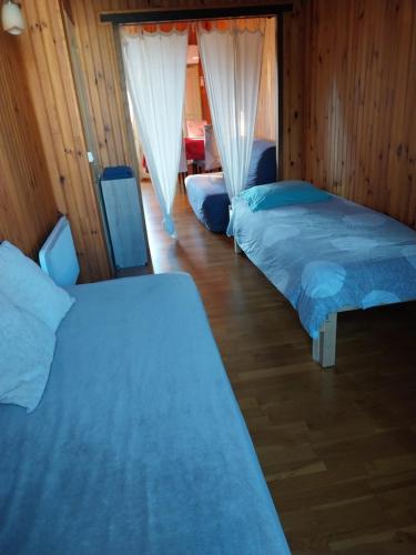 due letti in una stanza con pareti in legno di Vanessa et Julien 1 a Vailly-sur-Sauldre