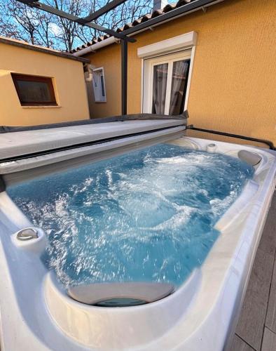 a hot tub with a toilet inside of it at Maison Les Chênes - Jacuzzi - Calme & Idéalement situé - Clim - Salle de Jeux - Parking in Sauzet