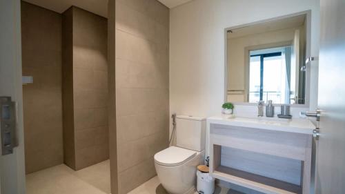 a bathroom with a toilet and a sink and a mirror at 6br Family Heaven Playground in Abu Dhabi