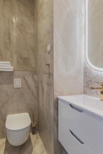 a bathroom with a white toilet and a sink at Rooms Indigo Bundek in Zagreb
