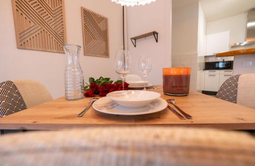 a wooden table with a bowl and wine glasses on it at Standing, confort, centre ville,4 personnes in Saint-Étienne