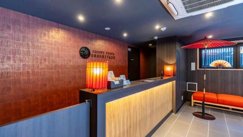 a restaurant with a bar with a red umbrella at Tabist GROOVE KYOTO OKOSHIYASU in Kyoto