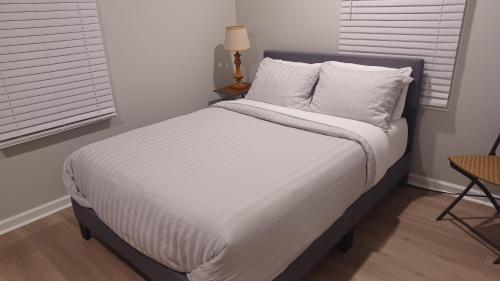 a bedroom with a large bed with white sheets and pillows at 1 Bedroom Piña Pecan House by Palace of Nobles in Charlotte