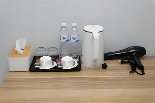 a tray with cups and water bottles on a desk at GO INN BTS Nana Sukhumvit Soi 3 x โกอินน์ บีทีเอส นานา ซอย 3 in Makkasan