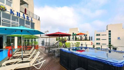a pool with chairs and umbrellas next to a building at 거제 아쿠아리우스 in Geoje 