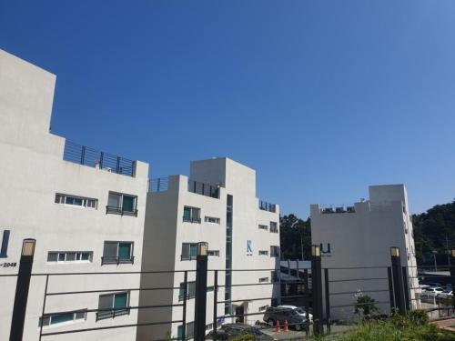 a large white building in front of a parking lot at 거제 아쿠아리우스 in Geoje 