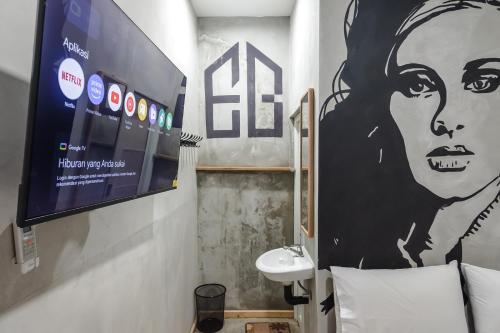 a bathroom with a large painting of a woman on the wall at INNCA Exotic Inn, Semarang in Semarang