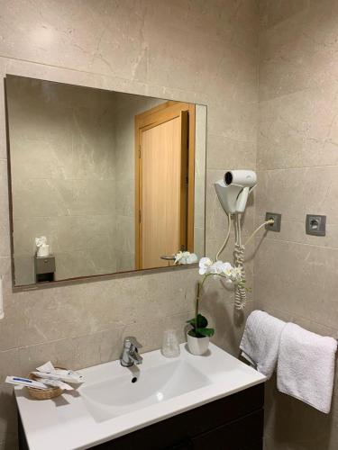 a bathroom with a sink and a large mirror at Hotel El Sueño de Jemik in La Roda