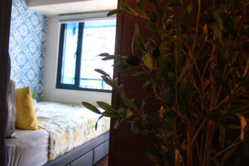 a bedroom with a bed and a window at Air Residences-Stylish&Comfort Stay High flat with balcony in Manila