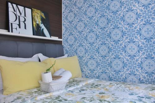 a bedroom with a bed with a yellow pillow and a wall at Air Residences-Stylish&Comfort Stay High flat with balcony in Manila